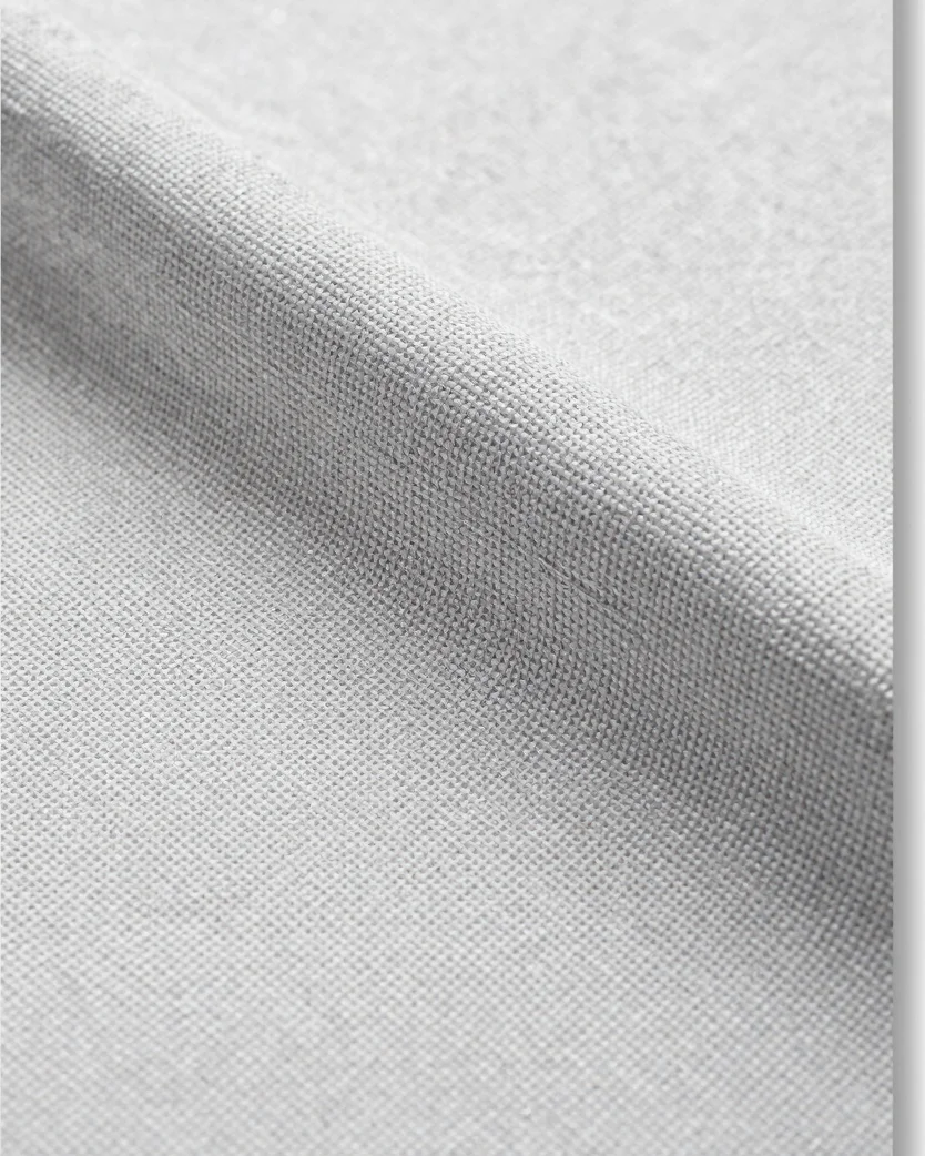 Macro close-up on a soft light-grey background of natural canvas